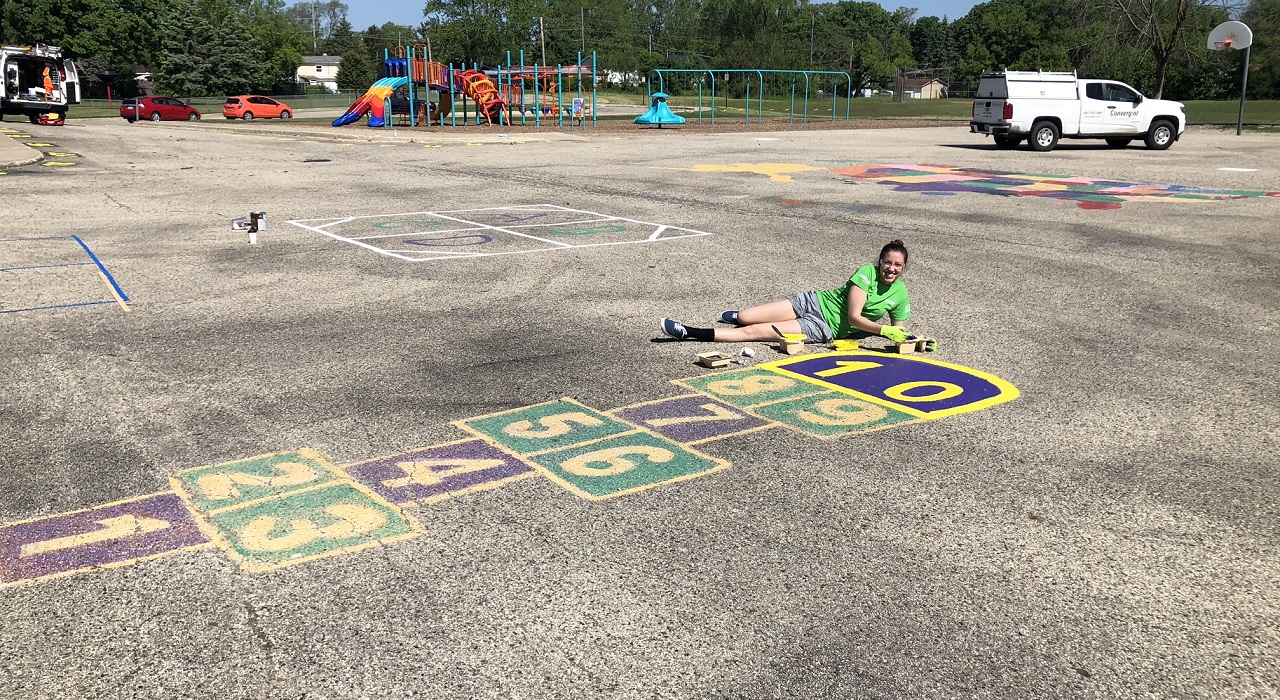 Colleague painting a hopscotch in a children's playground