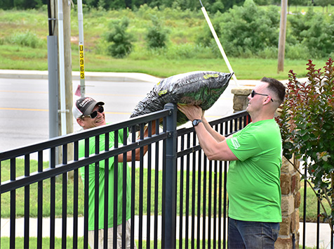 People handing supplies over a fence