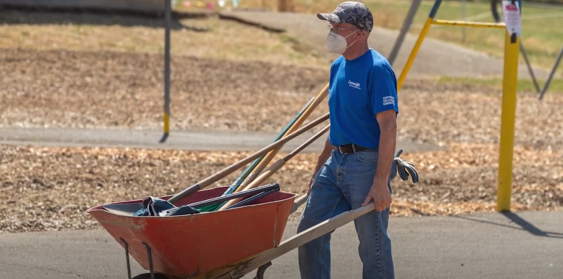 Colleague pushing wheelbarrow
