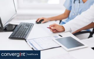 Female and Male doctor and nurse looking at reports and on computer