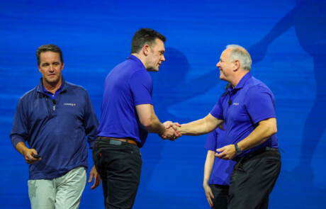 Two men shaking hands on stage
