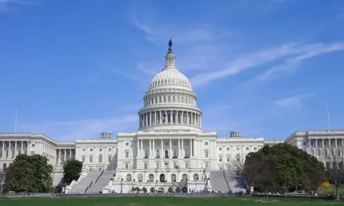 A picture of the US capitol building with a blue sky behind it