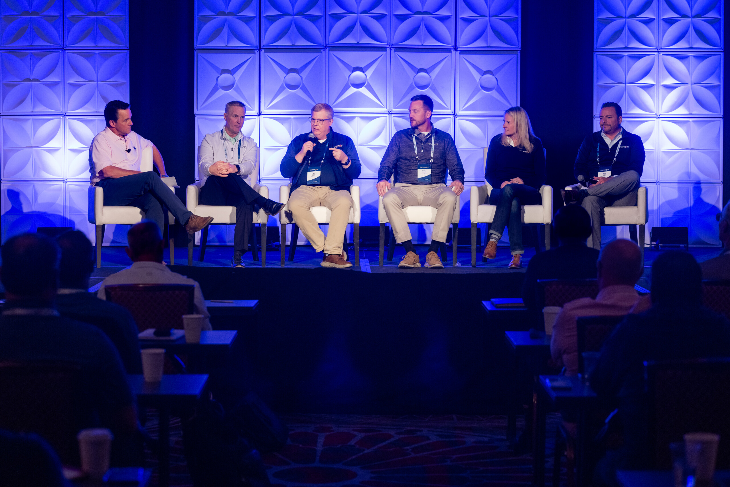A group of men and women sitting on a stage talking